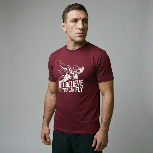 Athletic guy with cauliflower ear wearing Maroon T-Shirt with sign "I believe you can fly" depicting judo throw. Front
