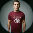 Athletic guy with cauliflower ear wearing Maroon T-Shirt with sign "I believe you can fly" depicting judo throw. Front
